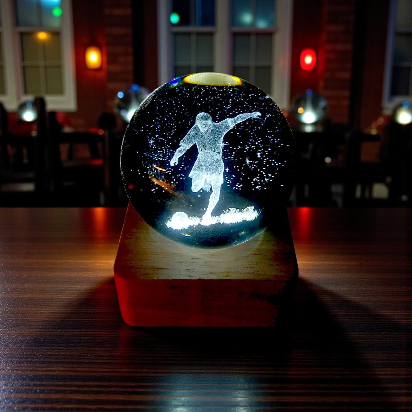 Sfera di cristallo luminosa con base in legno in tema calciatore